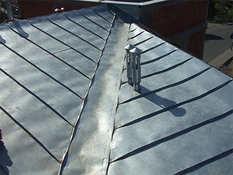 Two roof planes merging together into one, with complete tin flashings.