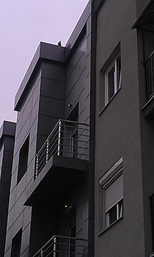 Building facade with terrace and window sill flashings.